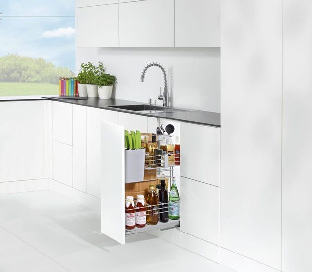 Une cuisine blanche et moderne avec un meuble d&rsquo;angle ouvert pr&eacute;sentant une solution de rangement organis&eacute;e pour les bouteilles