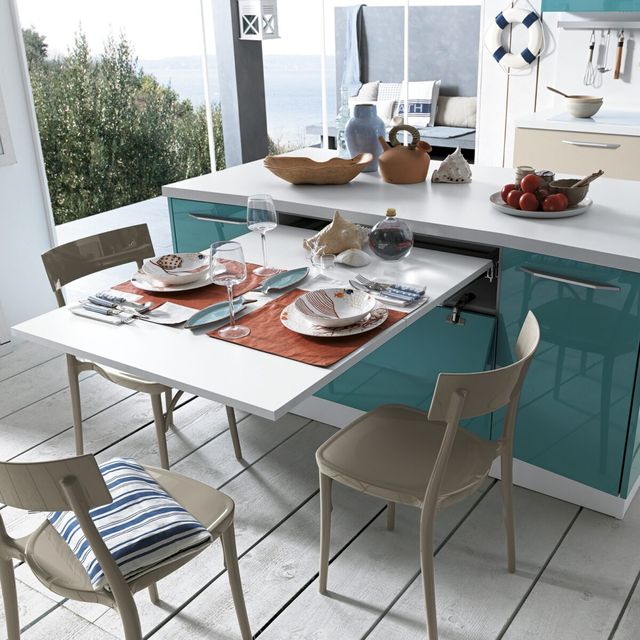 Une cuisine moderne et ensoleill&eacute;e avec vue sur l&rsquo;oc&eacute;an, comprenant une table &agrave; manger soigneusement dress&eacute;e avec une vaisselle &eacute;l&eacute;gante