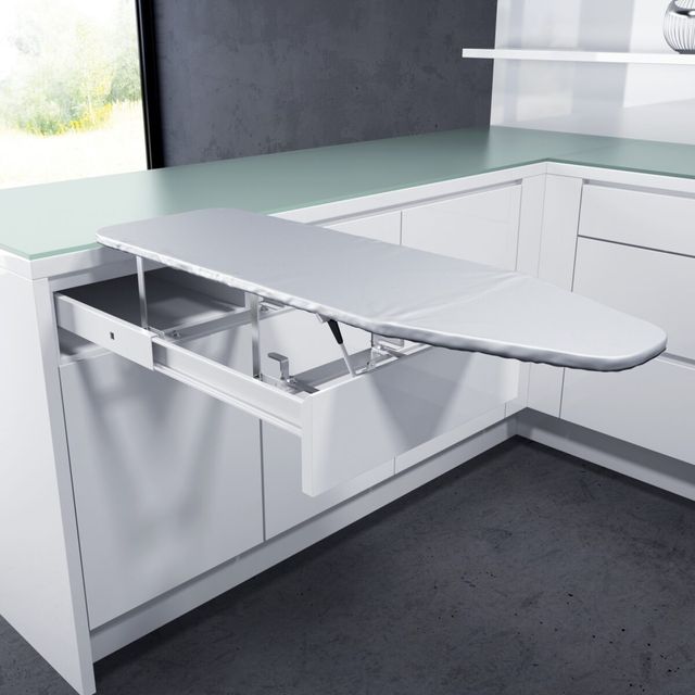 Une table &agrave; repasser int&eacute;gr&eacute;e moderne et peu encombrante prolong&eacute;e d&rsquo;un &eacute;l&eacute;gant tiroir blanc dans une cuisine contemporaine
