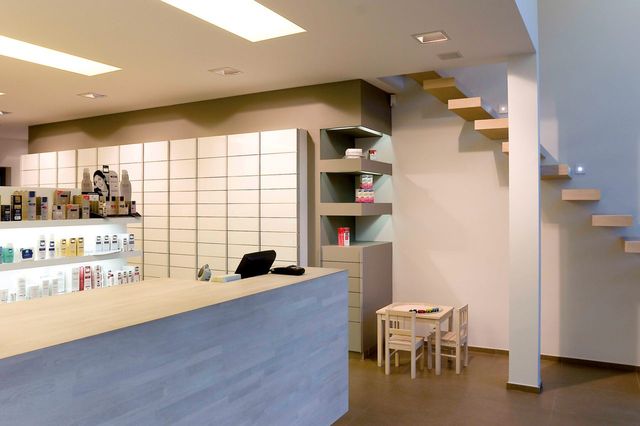 Un int&eacute;rieur moderne et minimaliste d&rsquo;une pharmacie, comprenant des escaliers flottants en bois