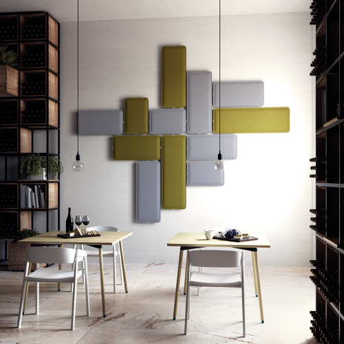 Salle &agrave; manger moderne comprenant deux tables minimalistes dress&eacute;es pour un repas, des &eacute;tag&egrave;res &eacute;l&eacute;gantes remplies de bouteilles
