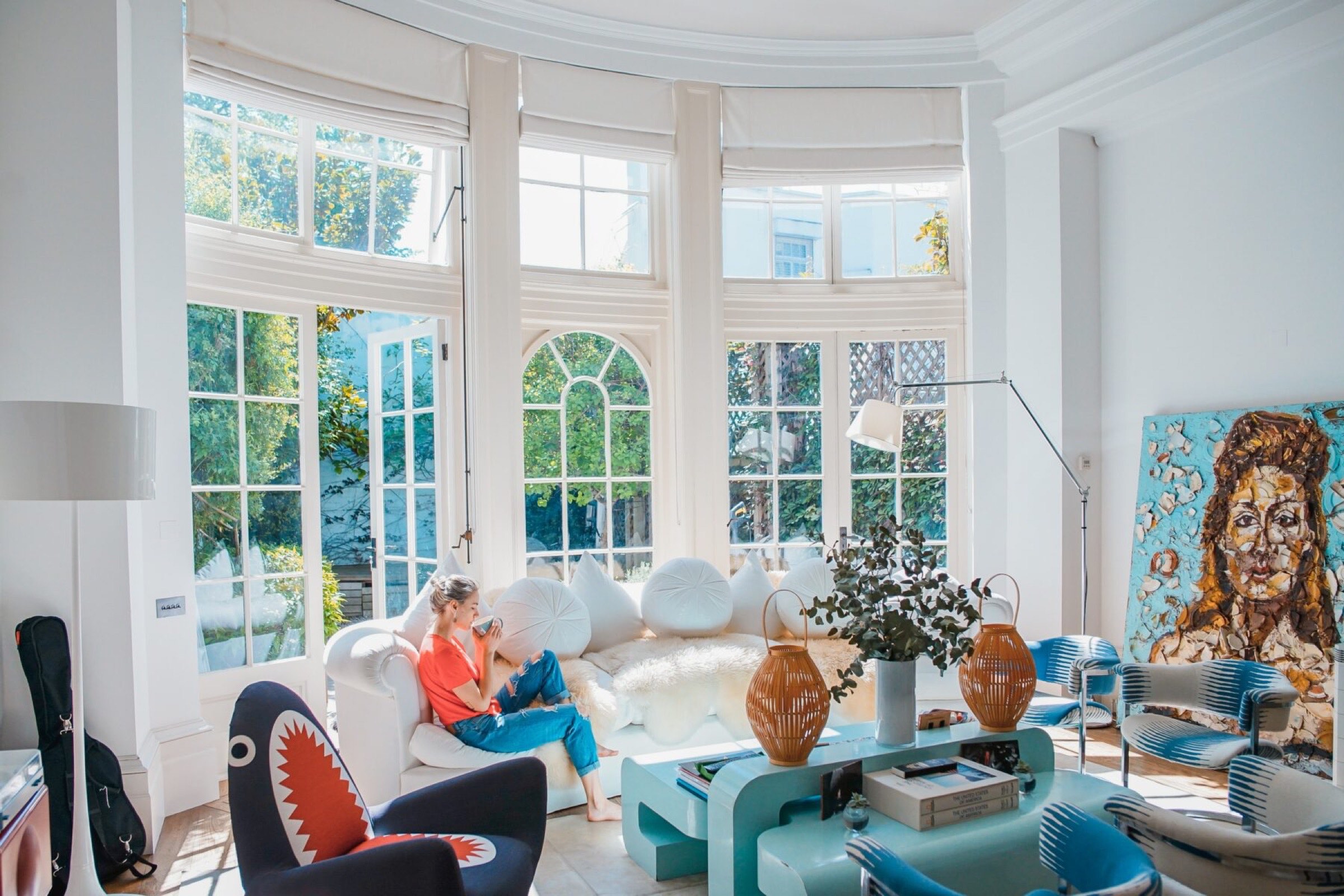 Un moment de s&eacute;r&eacute;nit&eacute; dans un salon lumineux et a&eacute;r&eacute; con&ccedil;u par un architecte d'int&eacute;rieur &agrave; Tarbes, avec une personne se reposant sur un canap&eacute;, dans une d&eacute;coration chic et une lumi&egrave;re naturelle qui y p&eacute;n&egrave;tre.