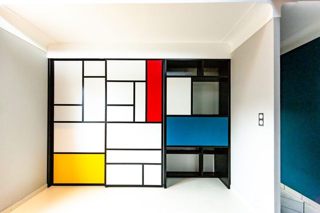 Panneau fa&ccedil;on Mondrian dissimulant placard et bureau