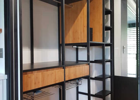 Bureau à domicile moderne avec étagères en métal noir et bureau en bois, doté d'un design minimaliste et d'un grand espace de rangement avec meubles sur mesure.