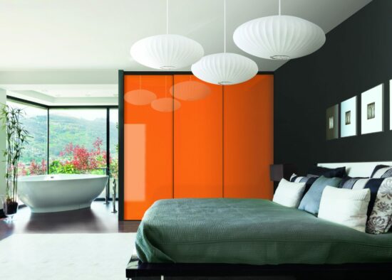 Chambre moderne et élégante avec une superbe porte coulissante orange, une élégante baignoire autoportante blanche et un lit accueillant avec des oreillers moelleux, le tout dans le contexte d'une pièce aux murs sombres et aux décorations personnalisées.