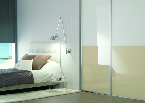 Chambre minimaliste moderne avec d'élégantes portes coulissantes blanches, un lit confortable avec une literie d'un blanc éclatant et des oreillers de couleur neutre, et une vue sereine sur la plage en arrière-plan, créant un espace de repos tranquille. La chambre aussi