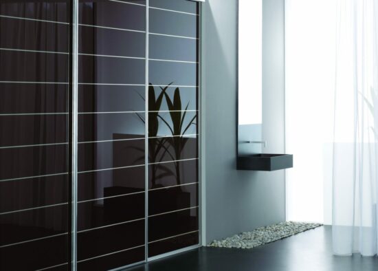 Intérieur moderne et minimaliste avec une élégante armoire noire, des étagères flottantes et une élégante silhouette de vase visible à travers des portes semi-transparentes dotées de meubles sur mesure.