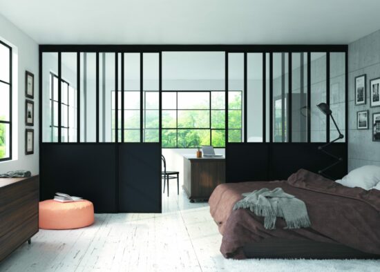 Chambre moderne et minimaliste avec des baies vitrées offrant une vue verdoyante, avec des meubles noirs et en bois élégants sur mesure et un lit marron confortable avec une couverture chaude.