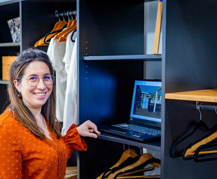 Une femme souriante travaillant sur un ordinateur portable sur un projet de dressing moderne et élégant